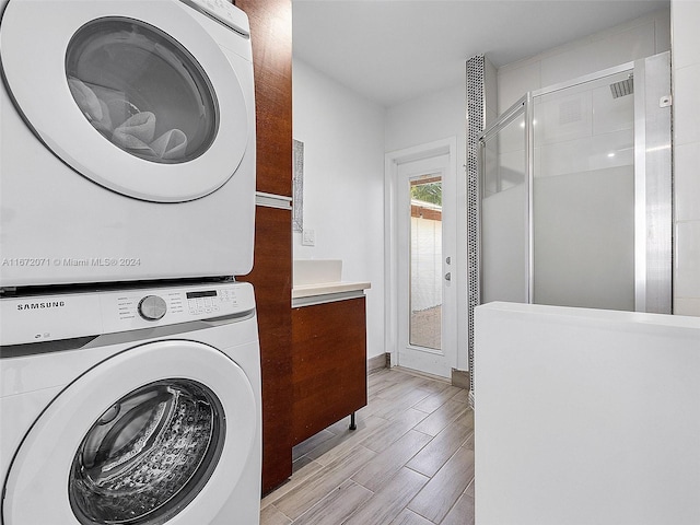 clothes washing area with stacked washer and dryer and light hardwood / wood-style floors