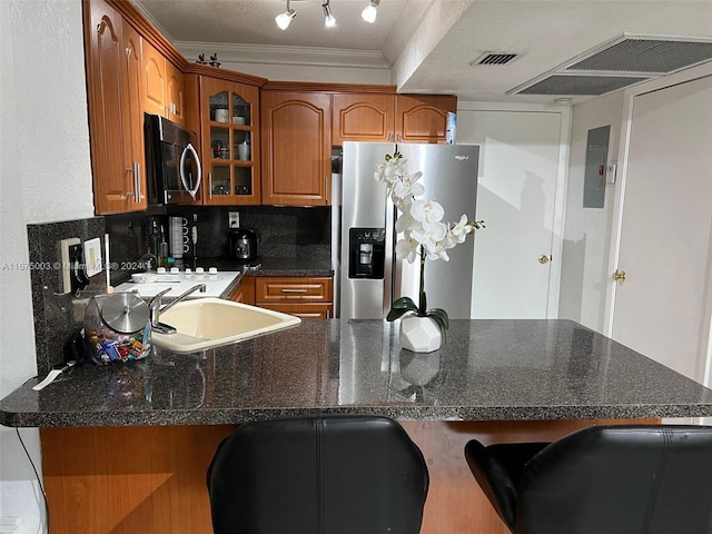 kitchen featuring decorative backsplash, sink, ornamental molding, kitchen peninsula, and appliances with stainless steel finishes