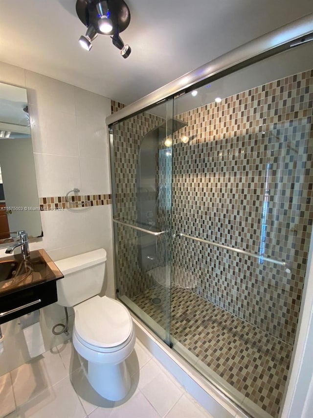 bathroom with tile patterned flooring, toilet, and a shower with shower door