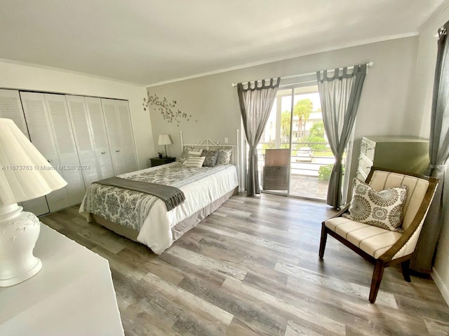 bedroom featuring hardwood / wood-style flooring, a closet, crown molding, and access to exterior