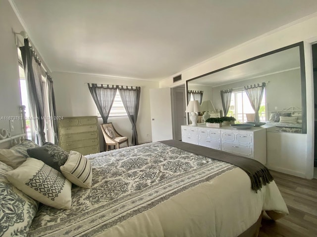 bedroom with crown molding and hardwood / wood-style floors