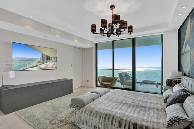 bedroom featuring a wall of windows, a water view, a notable chandelier, and access to outside