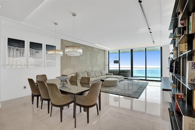 dining area featuring expansive windows and a water view