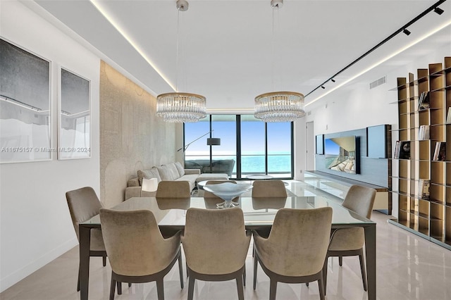 dining space featuring a water view and a notable chandelier