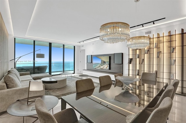 dining room with a wall of windows, a water view, and a notable chandelier