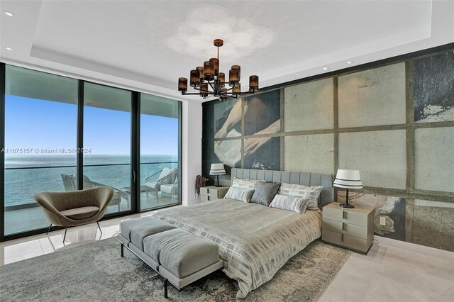 18975 Collins Ave Unit 2001, Sunny Isles Beach, FL 33160 - bedroom featuring a chandelier, recessed lighting, a wall of windows, a water view, and a raised ceiling