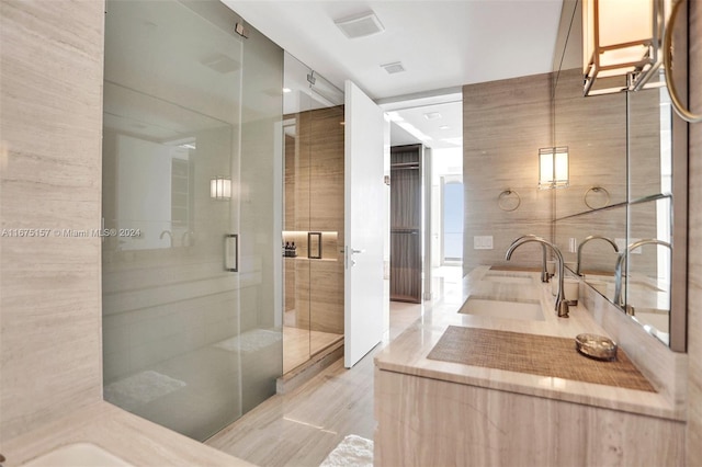 bathroom with tile walls, vanity, and a shower with shower door