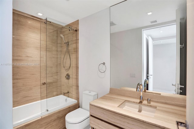 full bathroom with shower / bath combination with glass door, vanity, and toilet