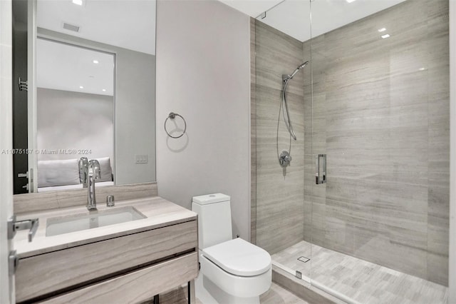 bathroom with vanity, a shower with shower door, and toilet