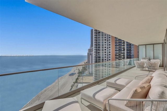 balcony featuring a water view and a beach view