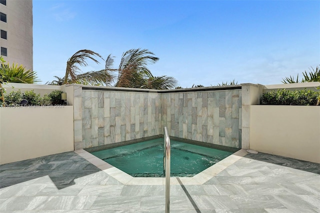 view of pool featuring an in ground hot tub