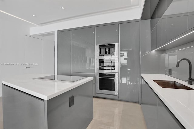 kitchen featuring gray cabinets, sink, double oven, and black electric stovetop