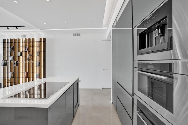 kitchen featuring black electric cooktop, double oven, and a center island