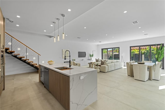 kitchen with decorative light fixtures, sink, light stone counters, a large island, and stainless steel dishwasher