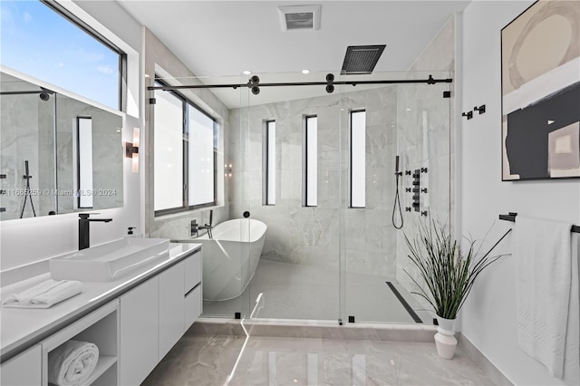 bathroom with vanity and shower with separate bathtub