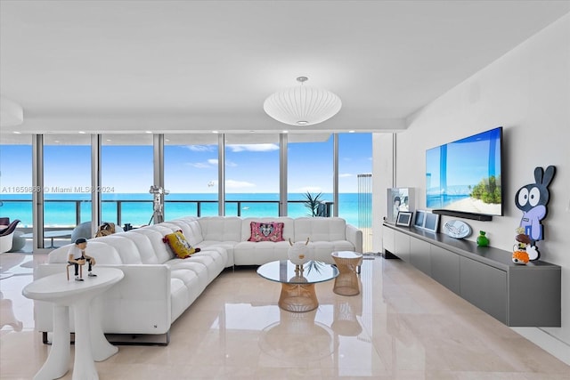 living room with expansive windows, plenty of natural light, and a water view