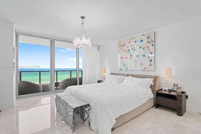 bedroom with access to outside, a chandelier, and a water view