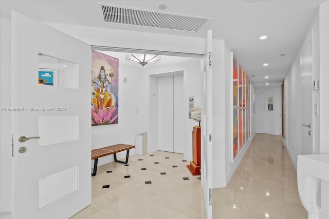 hall featuring tile patterned floors and elevator