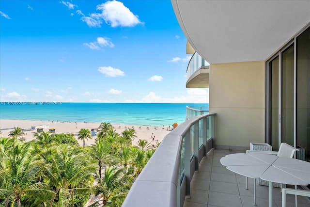 balcony featuring a water view and a view of the beach