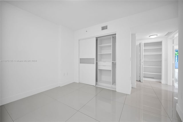 unfurnished bedroom with light tile patterned floors and a closet