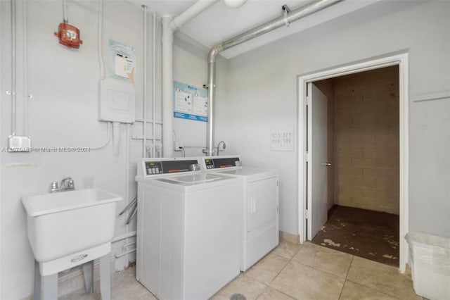 bathroom with tile patterned floors, washing machine and dryer, and sink