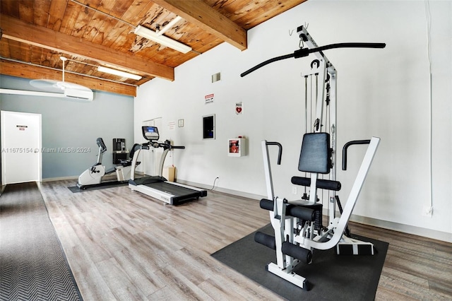 exercise room with a wall unit AC, wood ceiling, and hardwood / wood-style floors