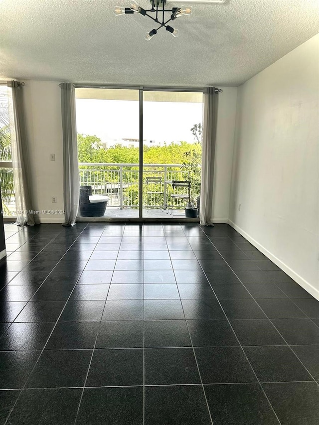 unfurnished room with a wall of windows and a textured ceiling