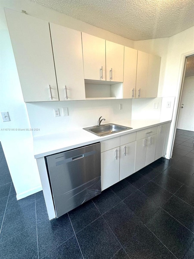 kitchen featuring a textured ceiling, sink, white cabinetry, and stainless steel dishwasher