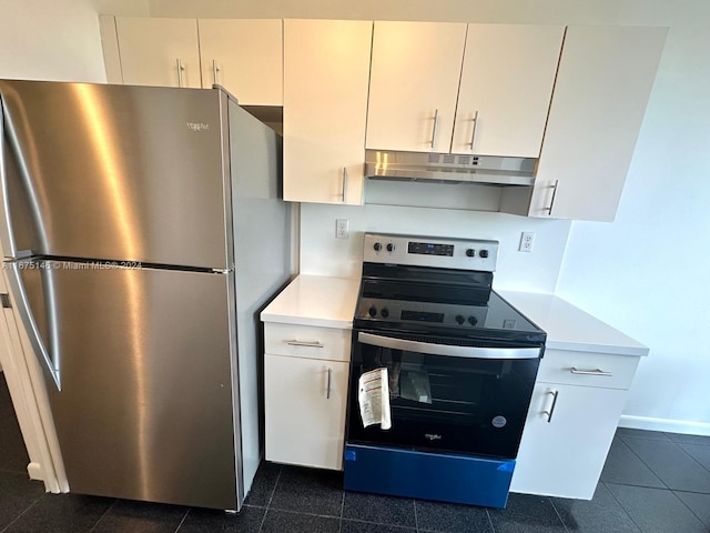 kitchen featuring dark tile patterned floors, white cabinetry, and stainless steel appliances