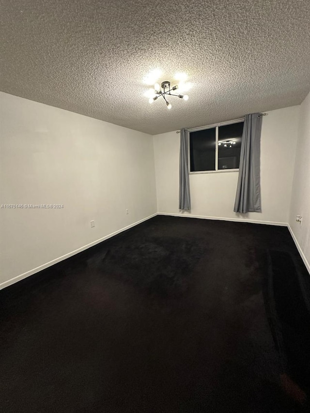 carpeted spare room with a textured ceiling