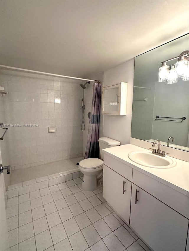 bathroom featuring tile patterned flooring, walk in shower, vanity, and toilet