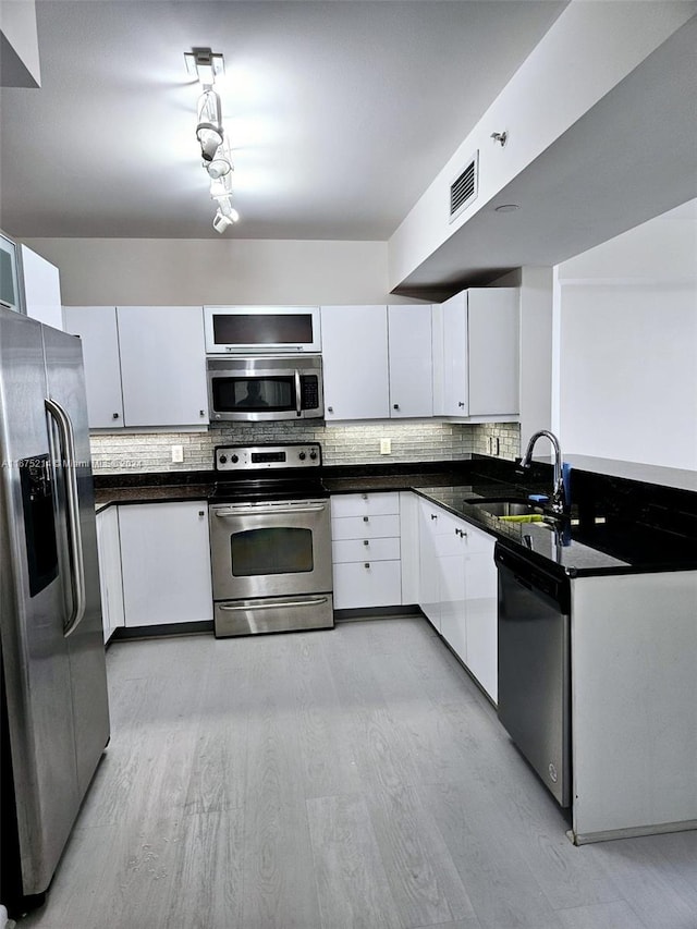 kitchen with light hardwood / wood-style floors, stainless steel appliances, sink, and white cabinetry