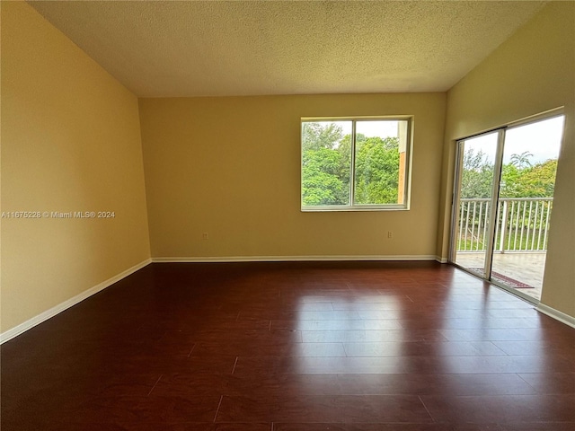 empty room featuring dark hardwood / wood-style flooring and a textured ceiling