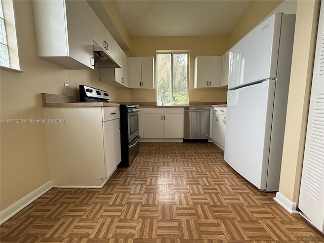 kitchen featuring white cabinets, appliances with stainless steel finishes, and light parquet flooring