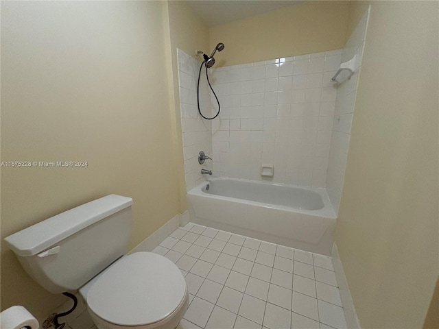 bathroom featuring tiled shower / bath, toilet, and tile patterned floors