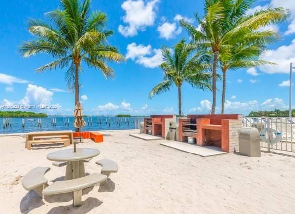 view of property's community with a water view and a beach view