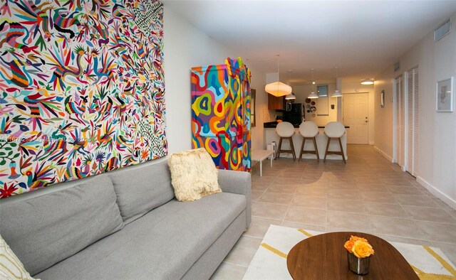 living area featuring tile patterned flooring and baseboards