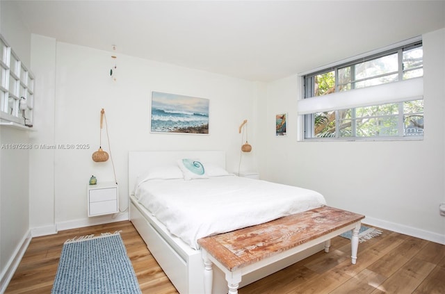 bedroom with baseboards and wood finished floors