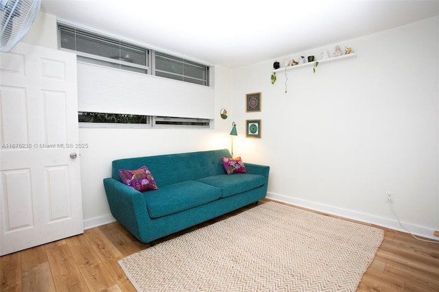 living area with baseboards and wood finished floors