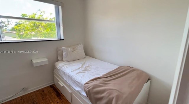 bedroom with dark wood-type flooring