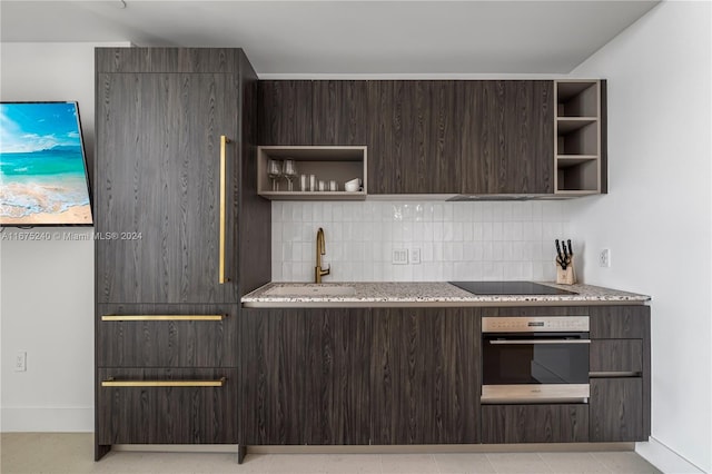 kitchen featuring dark brown cabinetry, stainless steel oven, sink, decorative backsplash, and black electric stovetop