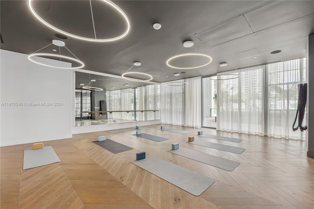 gym with parquet floors and a wall of windows