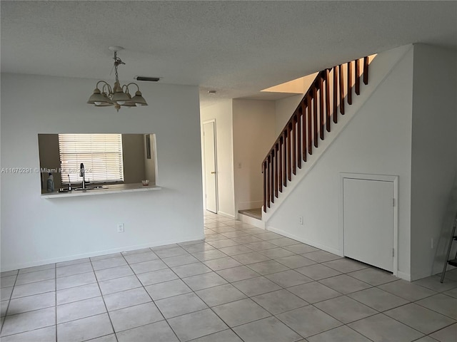unfurnished living room featuring a textured ceiling, visible vents, stairway, light tile patterned floors, and a notable chandelier