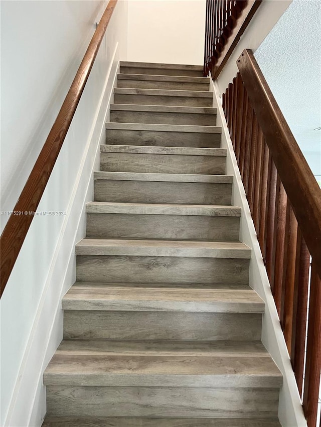 stairway with hardwood / wood-style floors