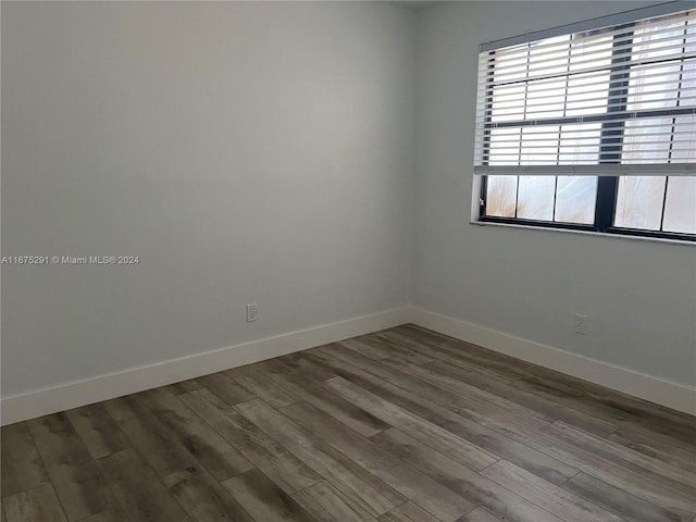 unfurnished room with baseboards and wood finished floors