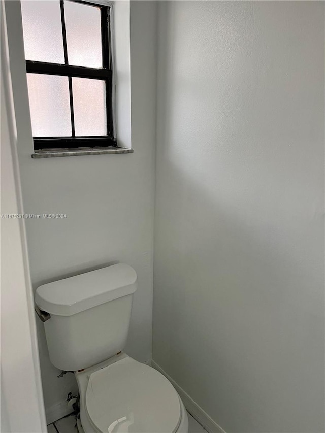bathroom with toilet and baseboards