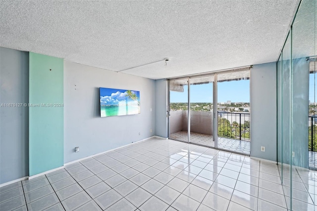 unfurnished room featuring light tile patterned flooring and a textured ceiling