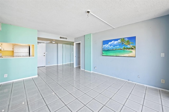 tiled empty room with a textured ceiling