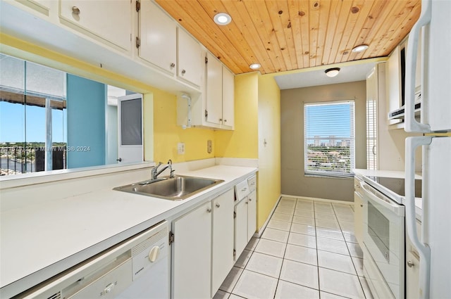 kitchen with white cabinetry, sink, light tile patterned floors, and range