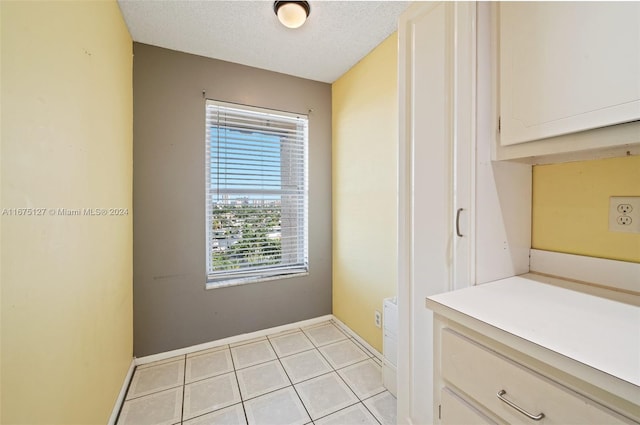 interior space with light tile patterned floors and a textured ceiling